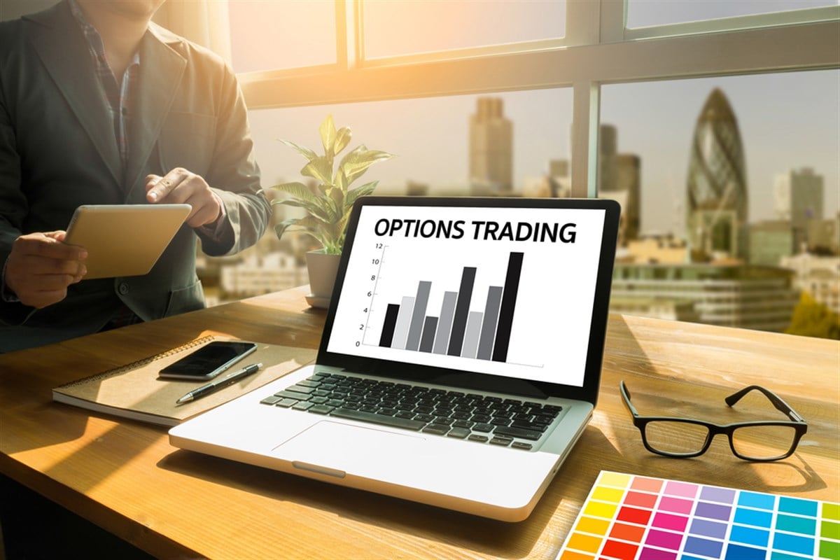 Photo of a desk with a computer showing Options Trading. Delta hedging is a defensive strategy used to temporarily reduce directional exposure. 